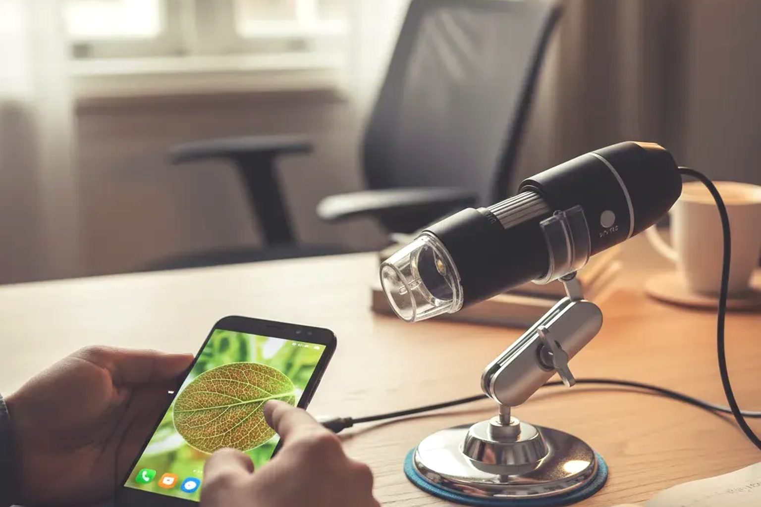 A USB digital microscope with eight LEDs on an adjustable stand viewing a postage stamp, showing enlarged perforations and a cancellation on a screen